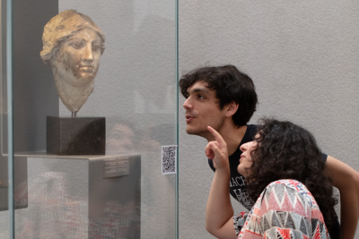 Visiteurs devant un buste 